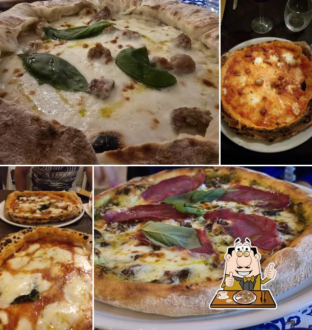 Pizza bianca appena sfornata con bocconi di salsiccia, foglie di basilico e un filo d'olio sulla mozzarella fusa