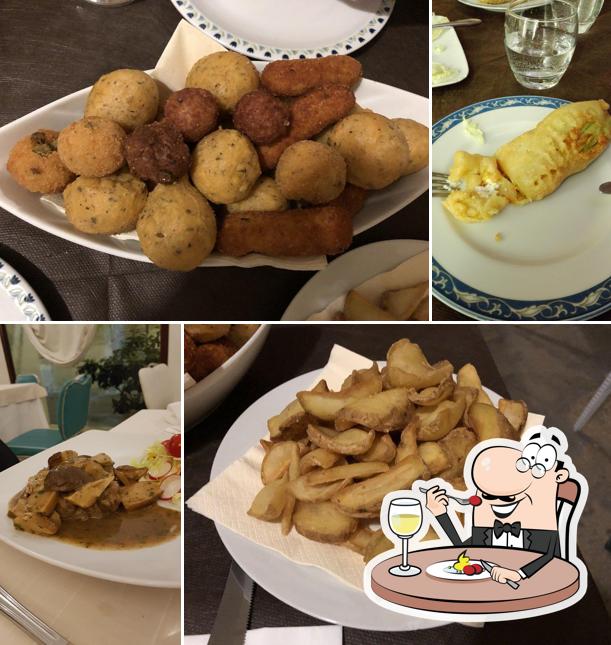 Cesto di fritti misti appena usciti dall'olio: crocchè di patate impanati, arancini e bocconi dorati, serviti su carta